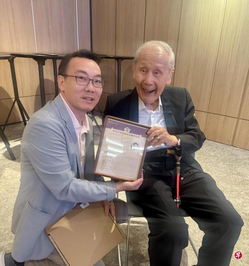 王赓武教授（右）收到自己70多年前在国立中央大学时的学籍档案和成绩单，95岁的长者笑得像个孩子。左边是新加坡江苏会会长周兆呈。（周兆呈提供）