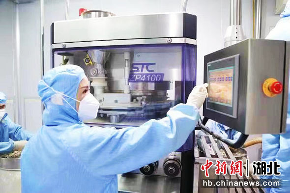 德源公司工人操作机器进行压片糖果生产。孙德力 摄